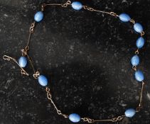 A 9ct gold and beaded glass stone contemporary necklace being chain linked.