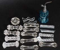 A collection of Victorian and later glass knife rests along with a blue glass perfume bottle