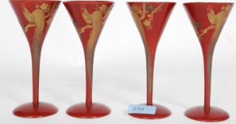 A group of four red laquered and gilt Chinese wine glasses having bird of paradise and foliate