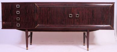 A vintage 1970's retro sideboard being raised on tapered legs supporting the wide body comprising