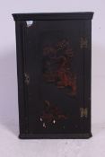 A 19th century Japanned black laquer chinoserie decorated corner cabinet having shelved interior