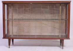 A retro 1950's display cabinet having twin glass sliding doors raised on tapered legs with mahogany