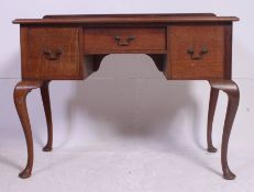 An Edwardian mahogany Queen Anne writing table desk raised on cabriole legs with pad feet having a
