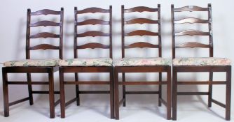A set of 4 Ercol dark wood ladderback dining chairs being raised on squared legs united by