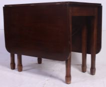 A large mahogany drop leaf dining table raised on squared supports.