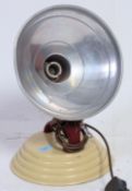 A retro vintage heat lamp having metal painted shade raised on an adjustable cast metal stand.