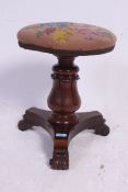 A Victorian mahogany tripod revolving piano stool having circular seat,