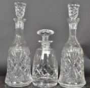 A collection of 3 cut glass decanters, all of differing design each with stoppers.