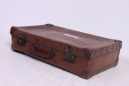 An early 20th century crocodile skin suitcase having handle to centre with hinged top.
