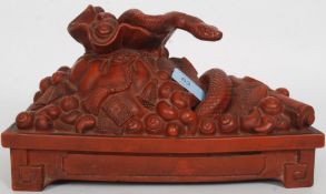 A Chinese Yixing stoneware statue of a snake intertwined with money sacks and Chinese good luck