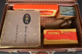 A vintage leather suitcase with contents to include a boxe vintage travel iron,