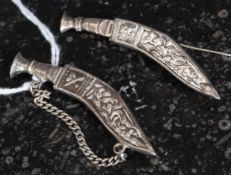 Two silver metal Kukri knife brooches ( tested for silver ) both having pin clasps to reverse