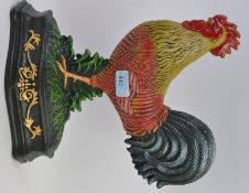 A cast metal and hand painted door stop in the form of a cockerel.