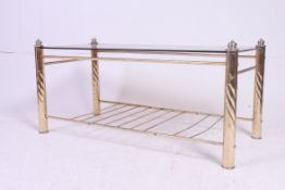 A vintage late 20th century brass and smoked glass coffee table having brass column supports with