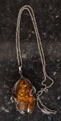 A large Art Nouveau ladies silver and amber pendant necklace.
