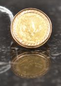 A 1980 gold one tenth Krugerrand coin being set within a 9 ct gold ring mount.