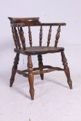 An antique style smokers bow - Windsor armchair chair raised on spindle legs united by stretchers