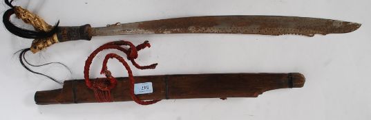 A 19th century antiue Sarawak Iban sword, with intricate carved bone handle stylised detail,