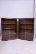 A good quality pair of oak bookcases with central wooden shelves,