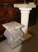 A stone sundial raised on a column plinth together with another stone sundial of lower squat form -