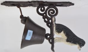 A 20th century cast iron wall hanging bell, with a Border Collie Dog to the top. Hand painted.