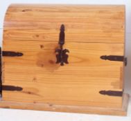 A contemporary pine dome top blanket box chest with cast metal ebonised brackets and handles to the