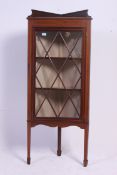 An Edwardian mahogany inlaid corner cabinet raised on tapered legs with spade feet having astragal
