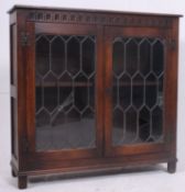 A jacobean style oak bookcase display cabinet having leaded glass with shelved interior.