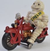 A 20th century figure of the Michelin Man riding a motorcycle
