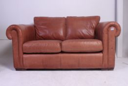 A Thomas Lloyd 2 seat brown leather chesterfield sofa settee having turned stub mahogany feet with