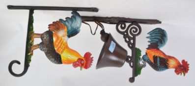 Two 20th century cast iron hand painted hanging items in the form of cockerell - one a bell the