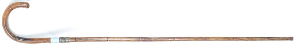 An Edwardian promenade walking stick cane, with hallmarked silver band to top.