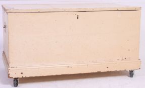 A vintage 20th century  pine painted / shabby chic trunk on later casters having hinged top