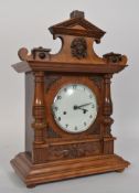 A 1930's oak cased mantel clock, with carved detail to top.