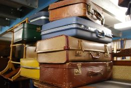 A stack of vintage suit cases to include different varieties to include American  etc