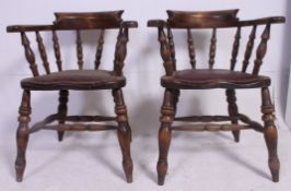 A pair of antique style smokers bow - Windsor armchairs chairs raised on spindle legs united by