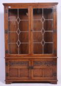 A Jaycee large gothic oak revival leaded glass bookcase cabinet having cupboard beneath glazed