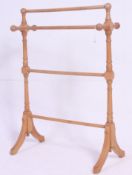 A 20th century Victorian style pine towel rail of turned wood construction on splayed feet