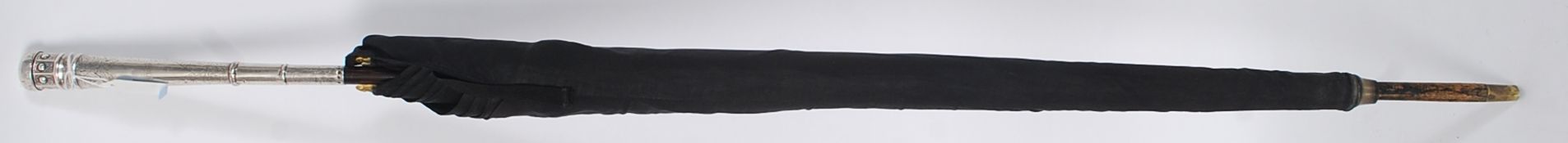 A silver hallmarked and rosewood gentlemans umbrella.