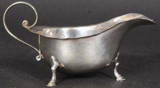 A Mappin & Webb silver hallmarked sauce boat being raised on hoof feet.