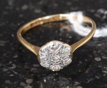 An 18ct gold and diamond ring with flower head having inset diamonds surrounding a star.