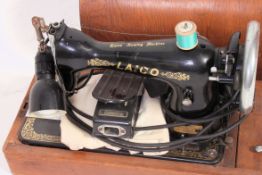 An early 20th century Singer sewing machine of typical form set within dome top carry case