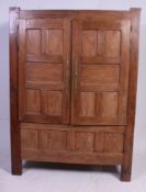 A 19th century French elm coffer armoire wardrobe raised on tall stile legs with fielded panel