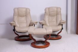 A pair of Norwegian designer Ekornes cream leather revolving Stressless reclining chairs with