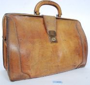 An early 20th century leather gladstone bag having folding top with central handle