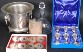 A collection of drinking related items to include a set of silver plated coasters, a wine cooler,