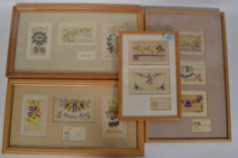 A collection of four framed and glazed silk post cards dating from the early 20th century,