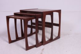 A retro 1970's G-Plan Kelso Nest of table in teak raised on squared  supports having graduating