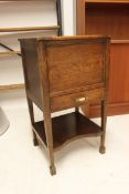 A late 1920's golden oak  pedestal sewing box having hinged top being rasied on squared legs