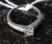 A ladies 9ct white gold diamond ring having central stone with channel set stones either side.